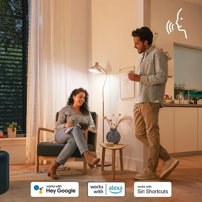 Philips Wiz Smart-LED-Lampe matter - E27, Dimmbar, RGBW, 470 lm, 4,9 W, 1 Stk. - Ein Paar entspannt sich in einem Smart Home, dessen Beleuchtung per Sprachassistenten wie Google, Alexa und Siri gesteuert wird.