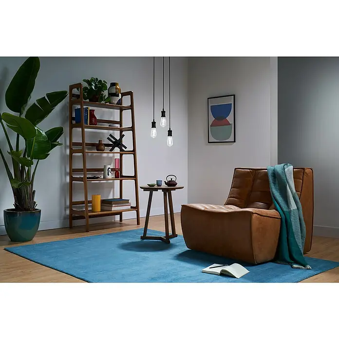 Philips Wiz Smart-LED-Lampe Edison - E27, Dimmbar, RGBW, 470 lm, 6,3 W, 1 Stk. - Drei hängende Edison-Pendelleuchten erhellen ein modernes Wohnzimmer mit braunem Sessel und blauem Teppich.