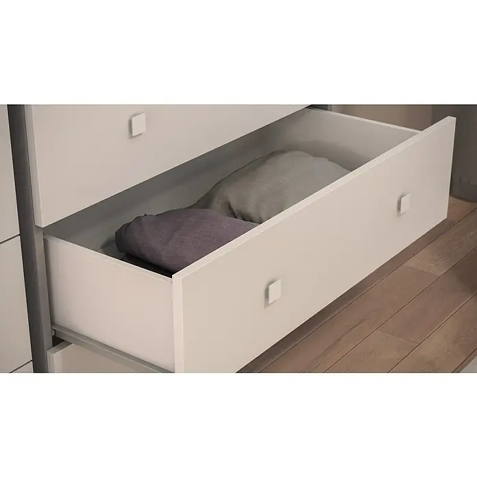 Meka Block Cómoda con mesitas de noche K-63 - 3 pzs., Cemento Grey/Blanco Liso - Cajón gris claro parcialmente abierto con tiradores cuadrados, conteniendo textiles grises y morados doblados. Suelo de madera.