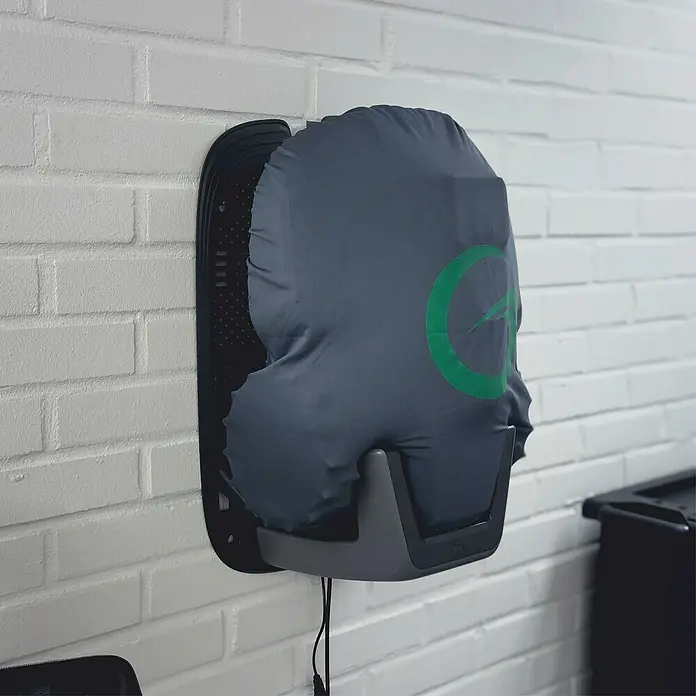 Grimsholm Green Abdeckhaube für Rasenmäher - L x B: 290 x 240 mm, Gängige Mähroboter-Modelle - Dunkelgraue Stoffabdeckung mit grünem Logo auf einem wandmontierten Gerät, möglicherweise einem Helmtrockner, mit Kabel.