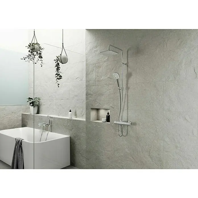 Hansa Micra Duschsystem Style - Lochabstand: 147 cm - 153 cm, Anzahl Strahlarten: 3 Stk., Chrom - Modernes Bad mit hellgrauen Fliesenwänden, einer weißen Badewanne und Chrom-Duscharmaturen.