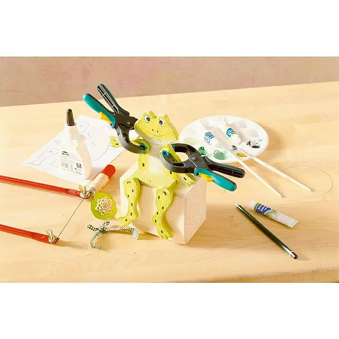 Wolfcraft Ratschenzwinge FZR 30 - Spannweite: 30 mm, Ausladung: 30 mm - Ein Frosch-Bastelset mit Klemmen, Farbe, Pinsel und Säge auf einem Holztisch. Ideal für kreative DIY-Projekte und Hobbybastler.