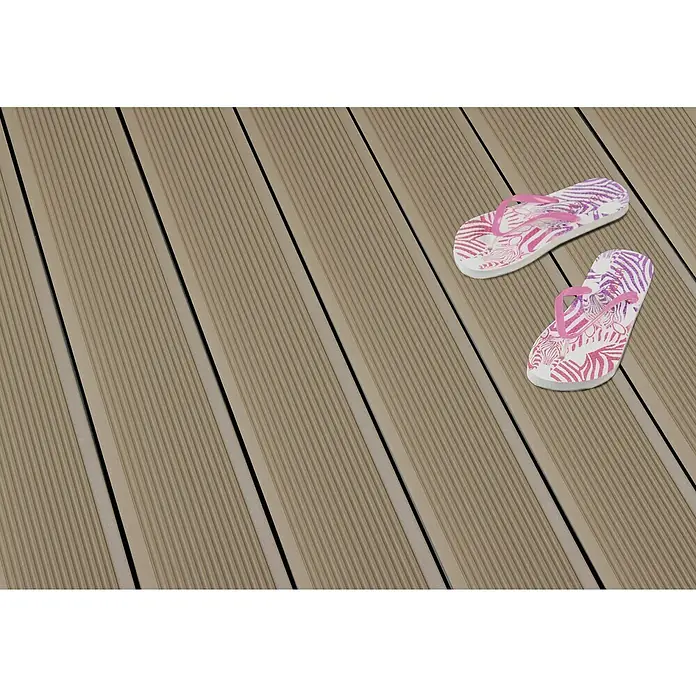 Kovalex WPC-Terrassendiele Exklusiv nach Maß - 500 x 14,5 x 2,6 cm, Sand - Ein Paar rosa und lila Zebrastreifen-Flip-Flops liegen auf einem hellbraunen Holzdeck.