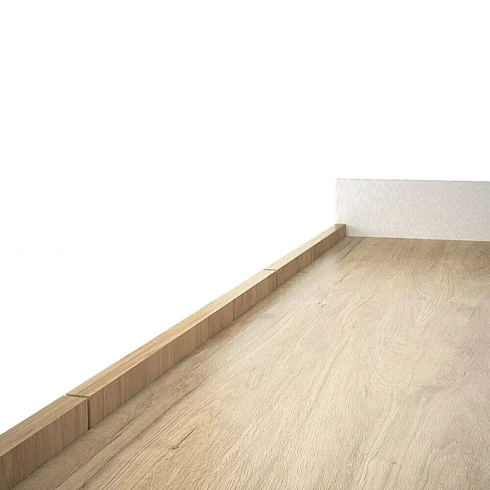 Meka Block Conjunto mueble de salón K-50 - 2 pzs., Blanco Poro/Roble Aurora - Suelo laminado efecto madera clara con rodapié a juego, junto a una pared texturizada clara.