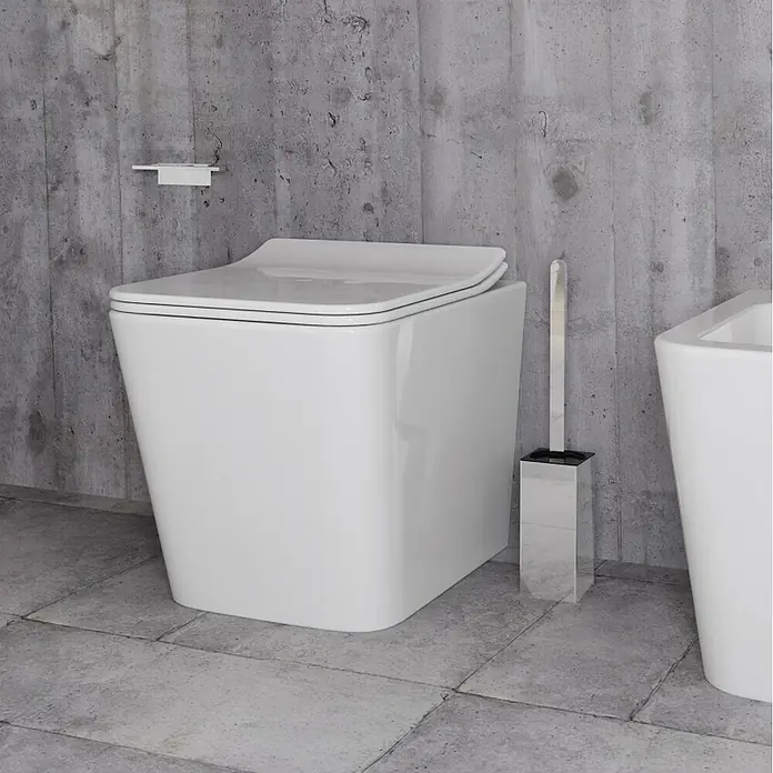 Escobillero de suelo Urban - Altura: 45 cm, Acero inoxidable, Cromado - Inodoro cerámico blanco moderno con diseño cuadrado, escobilla de WC cromada y portarrollos de pared en un baño.