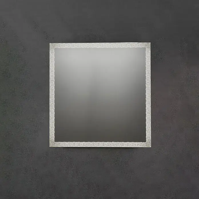 Espejo con luz Alhambra - 80 x 80 cm, Acero - Espejo rectangular con marco ornamental de patrón claro, montado en una pared oscura y texturizada.