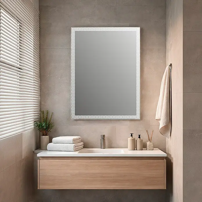 Espejo con luz Alhambra - 100 x 80 cm, Acero - Espejo de baño rectangular iluminado con un marco de patrón geométrico detallado, montado sobre un tocador de madera con lavabo.