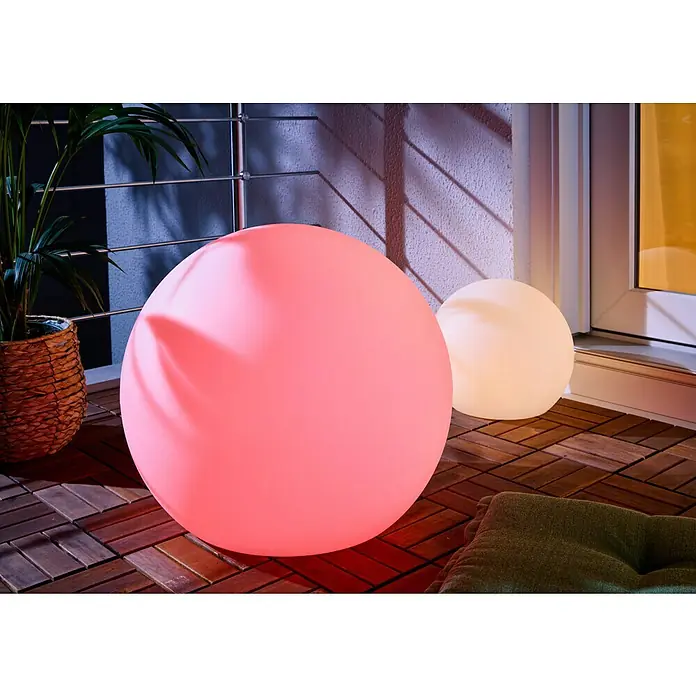 New Garden Solar-Dekoleuchte Buly - Durchmesser: 50 cm, IP65 - Zwei kugelförmige LED-Lampen, eine rosa und eine weiße, beleuchten eine Balkonterrasse.