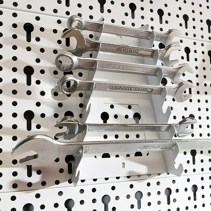 Element System Classic Lochwand-Set Organizer 2 - 2 x Stahllochplatten 80 x 20 cm, 2 x Wandschienen 50 cm, 19 verschiedene Werkzeughalter und Boxen, Montagematerial, 29 -tlg. - Eine Nahaufnahme von Schraubenschlüsseln, die ordentlich an einer weißen Lochwandhalterung für Werkzeuge aufgehängt sind.