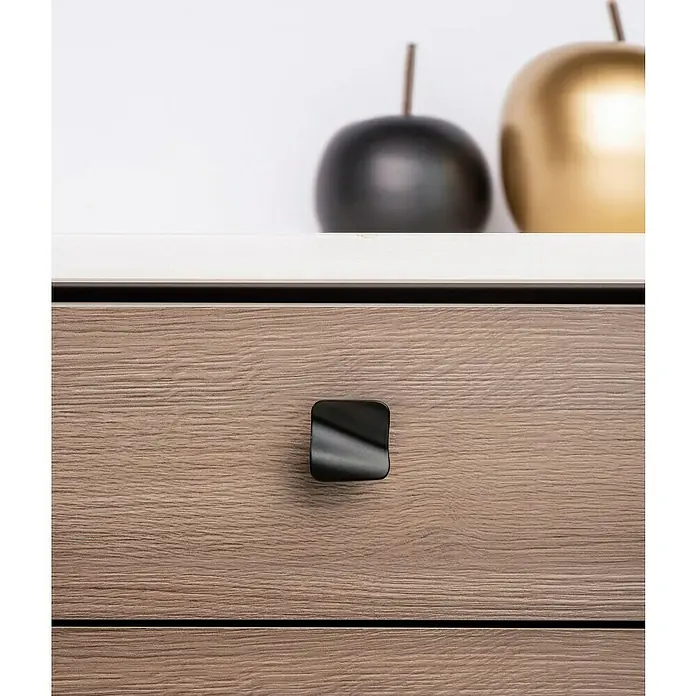 Rei Möbelknopf - Durchmesser: 32 mm, Schwarz - Schwarzer, quadratischer, moderner Schubladengriff an einer hellbraunen Holzschublade.