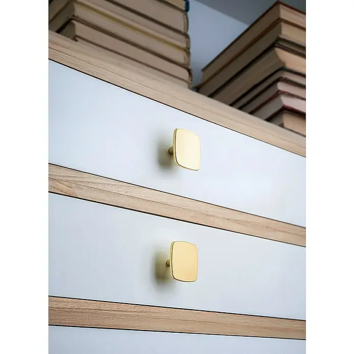 Rei Möbelknopf - Durchmesser: 42 mm, Gold - Goldene, quadratische Schubladengriffe an weißen Schubladen eines Holzschranks.