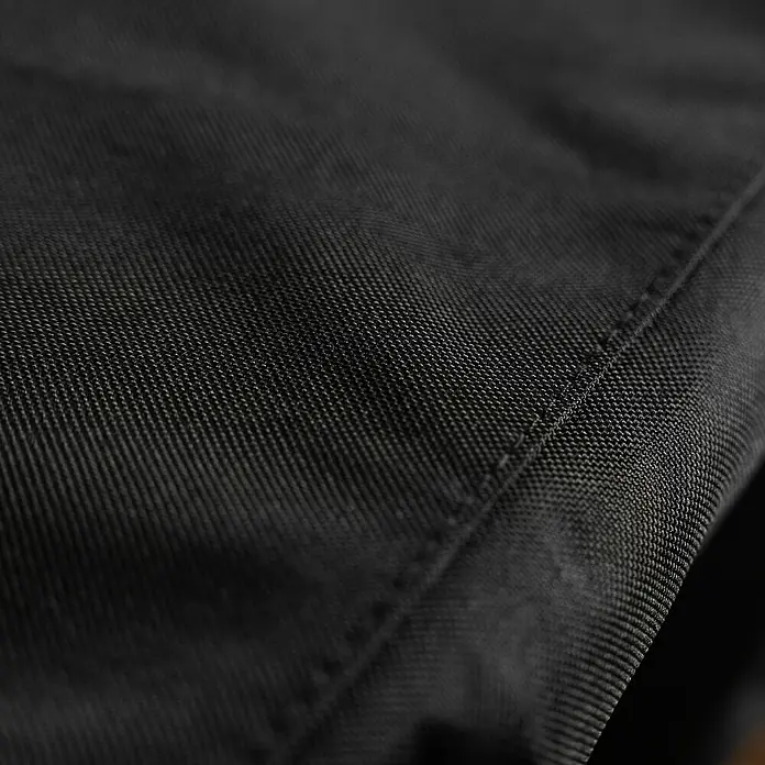 Blackstone Grill-Schutzhülle - Passend für: Blackstone Plancha-Grill 22", Polyester - Nahaufnahme von schwarzem Webstoff mit sichtbarer Naht, die die feine Textur des Materials hervorhebt.