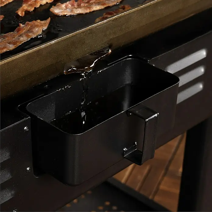 Blackstone Plancha Grill - Superficie de la parrilla (An x Pr): 91 x 55 cm, Negro, Número de quemadores: 4 ud. - Bandeja recogegrasa de metal negro recogiendo grasa de una plancha con tocino.