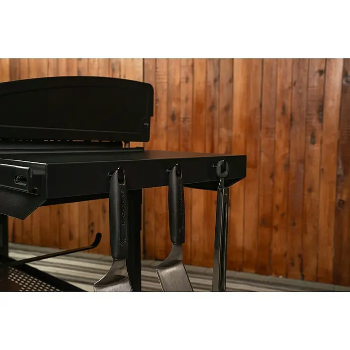 Blackstone Plancha Grill - Superficie de la parrilla (An x Pr): 91 x 55 cm, Negro, Número de quemadores: 4 ud. - Estante lateral negro de plancha con tres utensilios de cocina (espátulas, pinzas) colgados de ganchos.