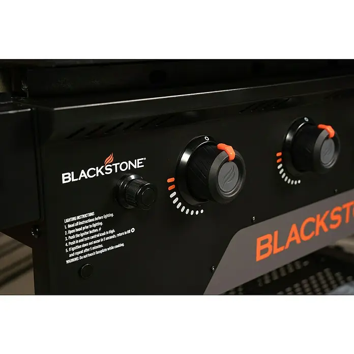 Blackstone Plancha Grill - Superficie de la parrilla (An x Pr): 91 x 55 cm, Negro, Número de quemadores: 4 ud. - Panel de control de plancha Blackstone negro con dos pomos negros, detalles naranjas e instrucciones de encendido.