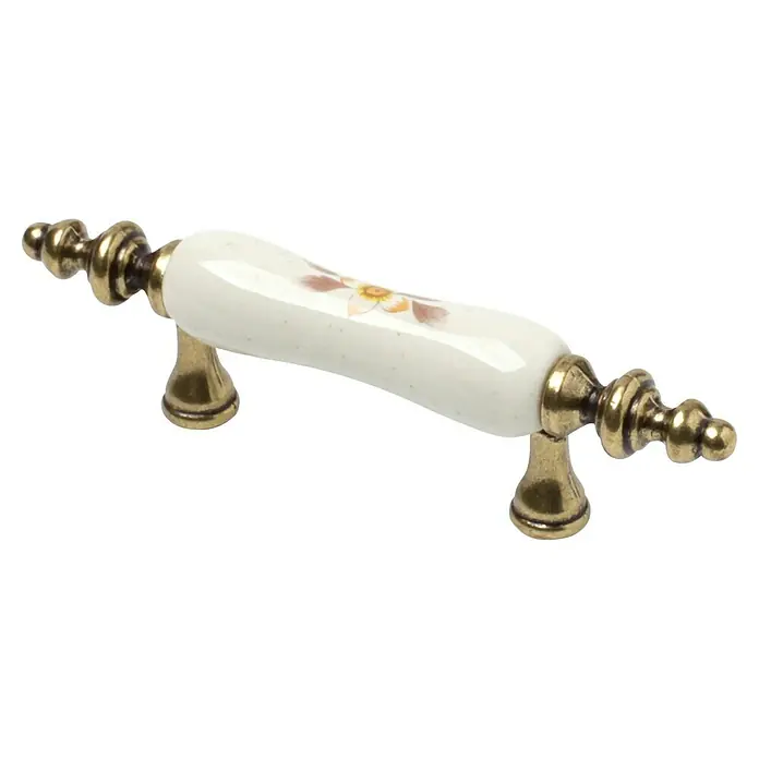 Rei Möbelgriff - Lochabstand: 64 mm, Porzellan, Antikes Messing, L x B x H: 124 x 18 x 31 mm - Weißer Keramik-Möbelgriff mit Antik-Messing-Finish und dezentem Blumendesign.