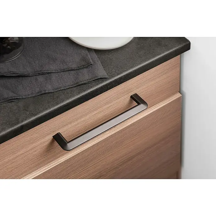 Rei Möbelgriff - Lochabstand: 160 mm, Sonstige, Schwarz, L x B x H: 181 x 8 x 35 mm - Dunkler Metallschrankgriff an einer Holzschublade unter einer dunklen Arbeitsplatte.