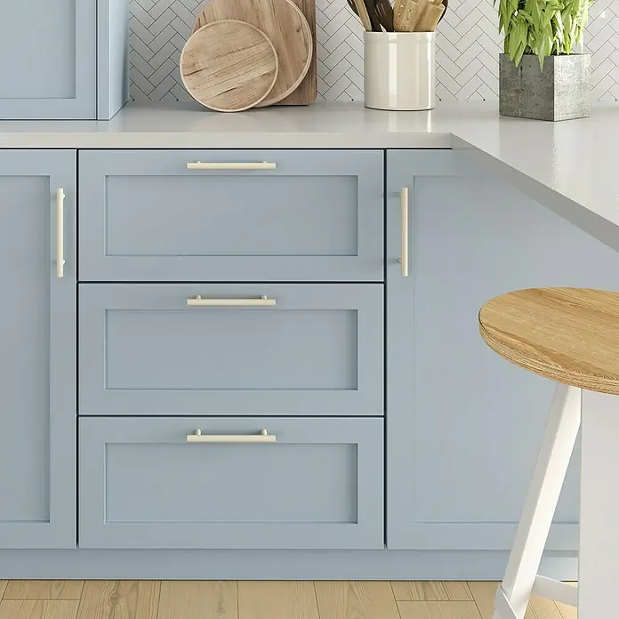 Rei Möbelgriff - Lochabstand: 96 mm, Stahl, Grau - Hellblaue Shaker-Schränke, cremefarbene Griffe, weiße Arbeitsplatte und Holzfußboden in einer Küche.