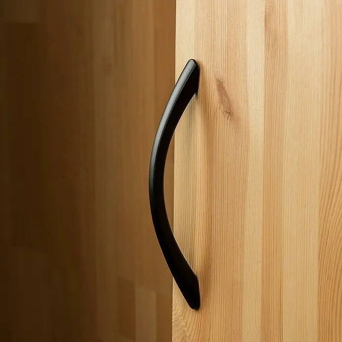 Rei Möbelgriff - Lochabstand: 128 mm, Aluminium, Schwarz, Design - Schwarzer, geschwungener Türgriff auf einer hellen Holzschranktür.