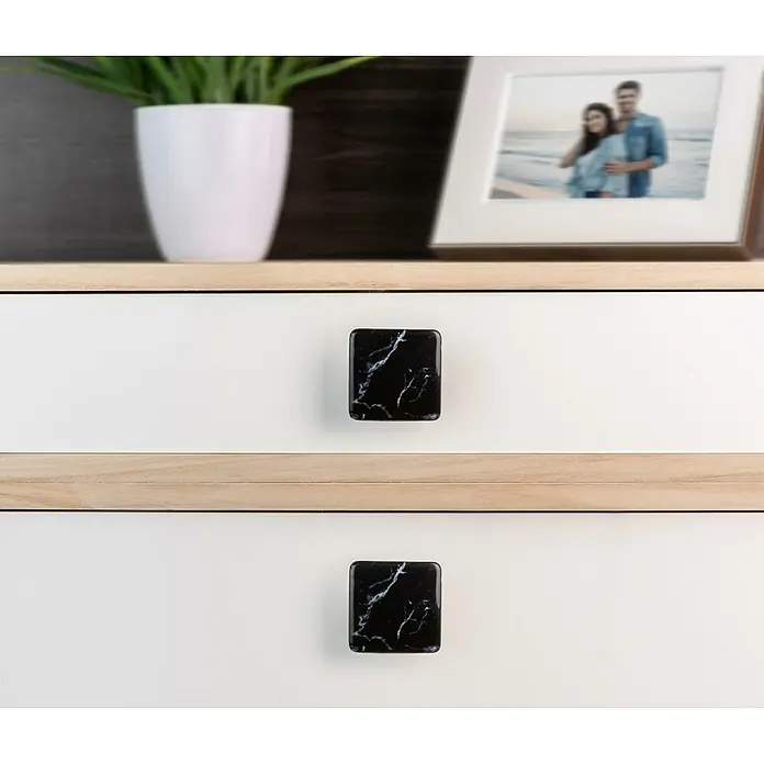 Rei Möbelknopf - Durchmesser: 37 mm, Schwarz - Zwei quadratische schwarze Marmor-Schubladengriffe an weißen Schubladen mit hellem Holzrahmen.