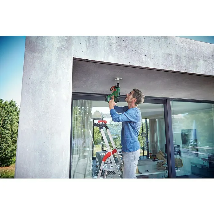 Bosch Professional AMPShare 18V Akku-Kombihammer UniversalHammer 18V - 18 V, 1 Akku, 4 Ah, 2 J - Mann auf Leiter benutzt grünen und schwarzen Akku-Bohrhammer, um etwas an Betondecke zu befestigen.