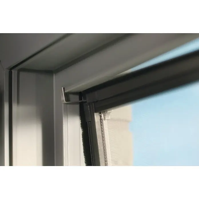 Tesa Insektenschutzfenster FALT für Fenster - Weiß, Montage Insektengitter: Klemmen - Silberne Halterung an grauem Fensterrahmen, sichert ein dunkles Moskitonetz vor hellblauem Himmel.
