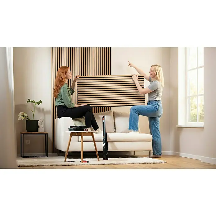 Alpha Tools Set de niveles de burbuja - 3 pzs. - Dos mujeres instalan paneles de pared insonorizantes de madera clara con Alpha Tools.