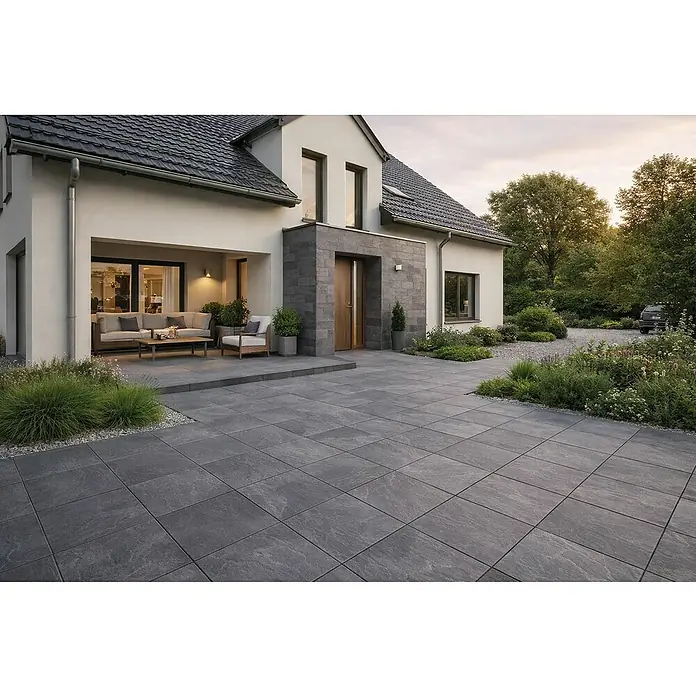 Terrassenfliese Tempio - 60 x 60 x 2 cm, Anthrazit, Matt - Dunkelgraue großformatige Pflasterplatten für Terrasse und Gehweg eines modernen Hauses, harmonisch in den Garten integriert.