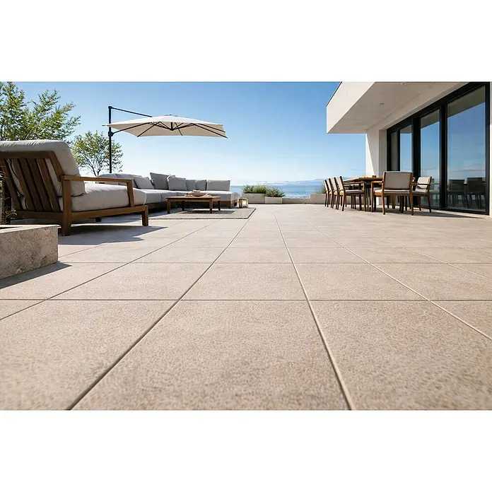 Terrassenfliese Urban Pro - 60 x 60 x 2 cm, Beige, Matt - Große, hellfarbene Terrassenfliesen schaffen einen eleganten Outdoor-Wohnbereich am Meer.