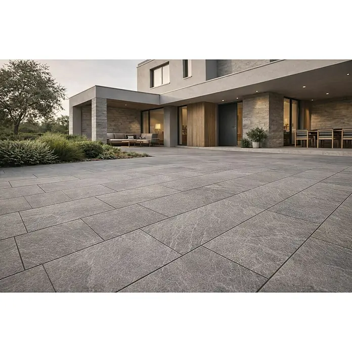 Terrassenfliese Tempio - 60 x 90 x 2 cm, Grey, Matt - Graue, strukturierte Pflastersteine bilden eine große Außenterrasse neben einem modernen Haus.