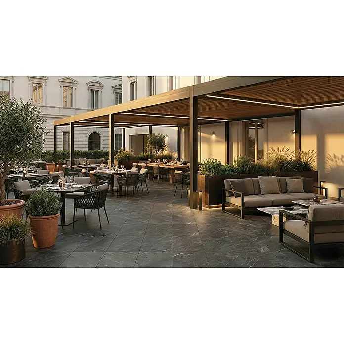 Terrassenfliese Total Stone - 60 x 90 x 2 cm, Grafit, Matt - Dunkelgraue marmorierte Outdoor-Bodenfliesen mit weißer Äderung in einem stilvollen Restaurant-Außenbereich.