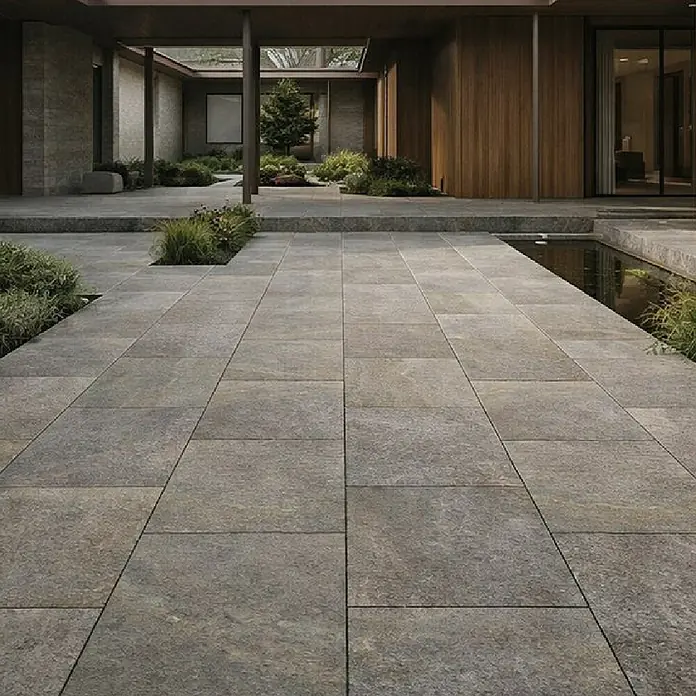 Terrassenfliese Torre - 40 x 80 x 2 cm, Luserna Mista, Matt - Texturierte graue rechteckige Außenpflasterplatten bilden einen Weg in einem modernen Hof mit Landschaftsgestaltung und Wasserspiel.