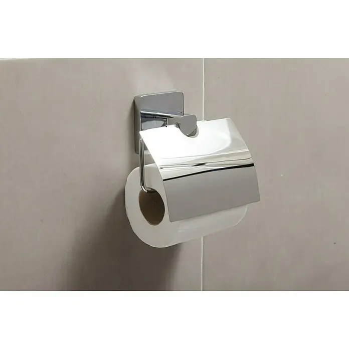Tatay Kalo Portarrollos papel higiénico - Con tapa, Cromo - Un portarrollos de papel higiénico con una cubierta cromada brillante está montado en la pared de un baño, sosteniendo un rollo de papel.