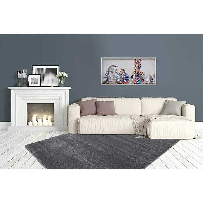 Kurzflorteppich Softtouch - Grau, 290 x 200 cm, 100 % Polypropylen (Flor) - Einrichtungsidee mit einem grauen Teppich, der einen Raum mit Sofa, Kamin und einem Kunstwerk mit Zebras gemütlich gestaltet.