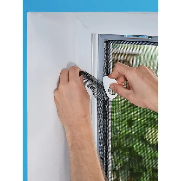 Tesa Insect Stop Insektenschutzgitter Premium - B x H: 120 x 250 cm, Weiß, Montage Insektengitter: Ankletten - Hände montieren ein schwarzes Fliegengitter mit einem weißen Montagewerkzeug in einen Fensterrahmen.