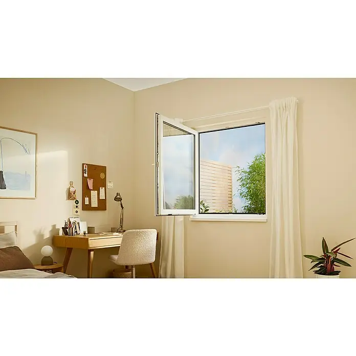 Tesa Insect Stop Insektenschutzgitter Premium - B x H: 130 x 150 cm, Anthrazit, Montage Insektengitter: Ankletten - Ein geöffnetes weißes Fenster in einem hellen Raum, das natürliches Licht und frische Luft über einem Holzschreibtisch hereinlässt. Draußen ist ein Gartenblick sichtbar.