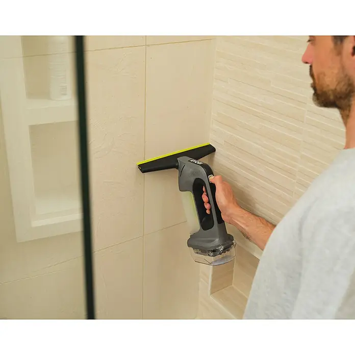 Ryobi ONE+ Akku-Fenstersauger RWV18-0 - 18 V, Ohne Akku - Mann reinigt mit einem grau-schwarzen Ryobi Fenstersauger mit grüner Klinge eine geflieste Duschwand.