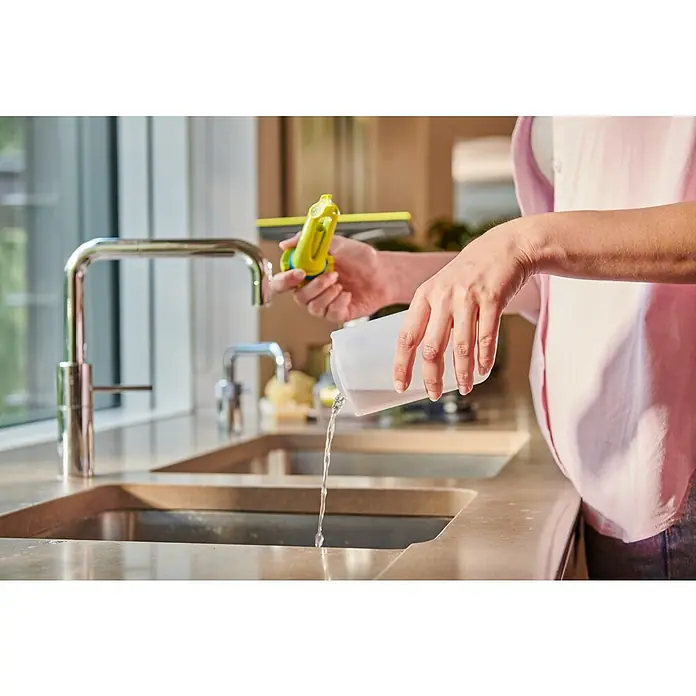 Ryobi ONE+ Akku-Fenstersauger RWV18-0 - 18 V, Ohne Akku - Person gießt Wasser aus weißem Behälter in Spüle; gelber Abzieher sichtbar.