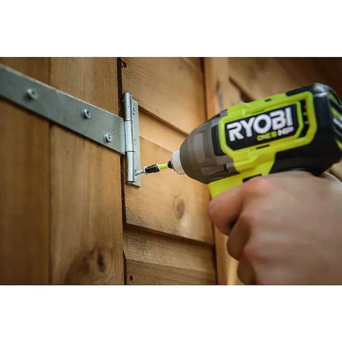 Ryobi Bit-Set RARXSD45 - 45 -tlg. - Limettenfarbener und grauer Ryobi Schlagschrauber schraubt eine Silberschraube in ein Scharnier auf einer Holzoberfläche.