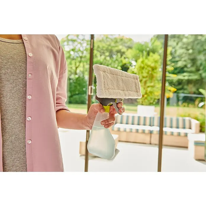 Ryobi ONE+ Akku-Fenstersauger RWV18-0 - 18 V, Ohne Akku - Person hält ein Fensterreinigungsgerät mit Sprühflasche und hellem, flauschigem Pad, reinigt eine Glastür.