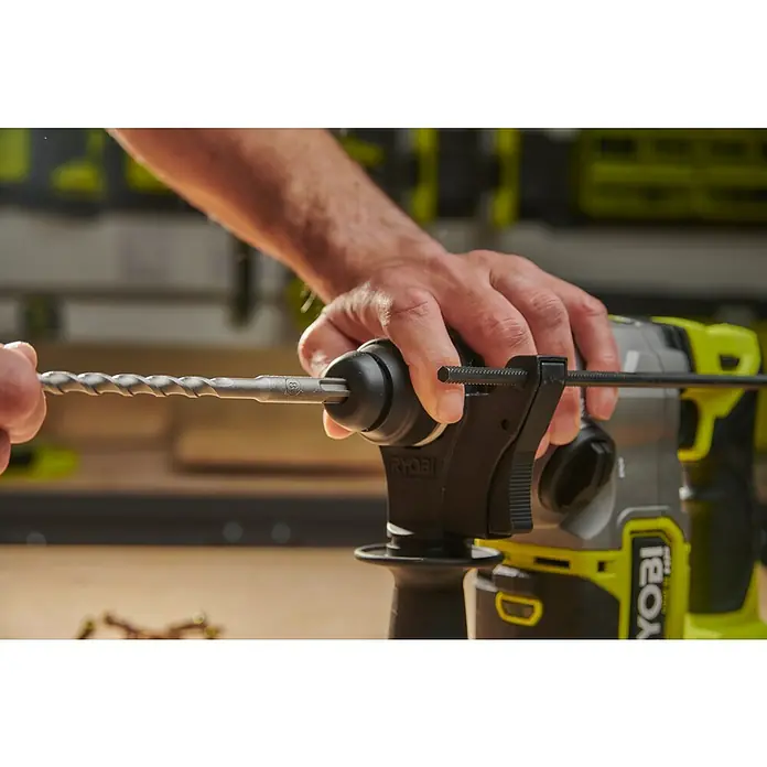 Ryobi Bohrer- & Bit-Set RARXSDS5 - 11 -tlg. - Hand steckt einen Bohrer in einen grün-schwarzen Ryobi Bohrhammer.