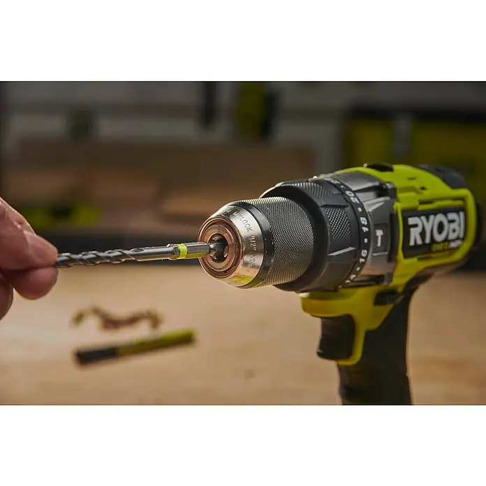 Ryobi Bohrer- & Bit-Set RARXMM7 - 13 -tlg. - Eine Hand steckt einen silbernen Bohrer mit grünem Akzent in das Bohrfutter eines grün-schwarzen Ryobi Akkubohrers.
