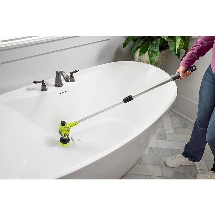 Ryobi 4V USB Akku-Reinigungsbürste RTS4-120G - 4 V, Ohne Akku - Person reinigt eine weiße Badewanne mit einem grünen und schwarzen ausziehbaren Kraftschrubber. Er hat eine silberne Stange und einen rotierenden Bürstenkopf.