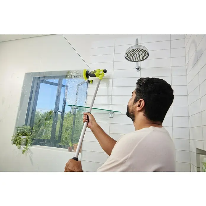 Ryobi 4V USB Akku-Reinigungsbürste RTS4-120G - 4 V, Ohne Akku - Mann reinigt Duschwand mit gelb-grauem, langstieligem Elektroschrubber, Seifenschaum ist sichtbar.