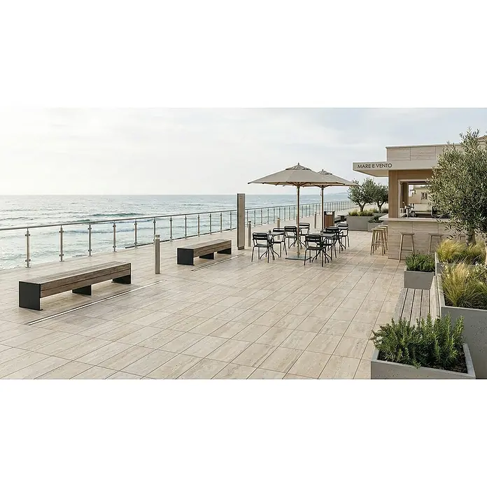 Terrassenfliese Duomo - 60 x 90 x 2 cm, Travertino, Matt - Hellbraune rechteckige Terrassenfliesen auf einer Außenterrasse mit Meerblick.