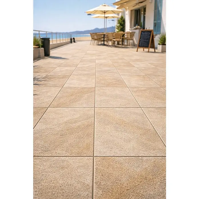 Granulati Zandobbio Terrassenfliese Etna - 40 x 80 x 2 cm, Cappucino, Matt - Helle, strukturierte Outdoor-Terrassenfliesen in einem Café am Strand.