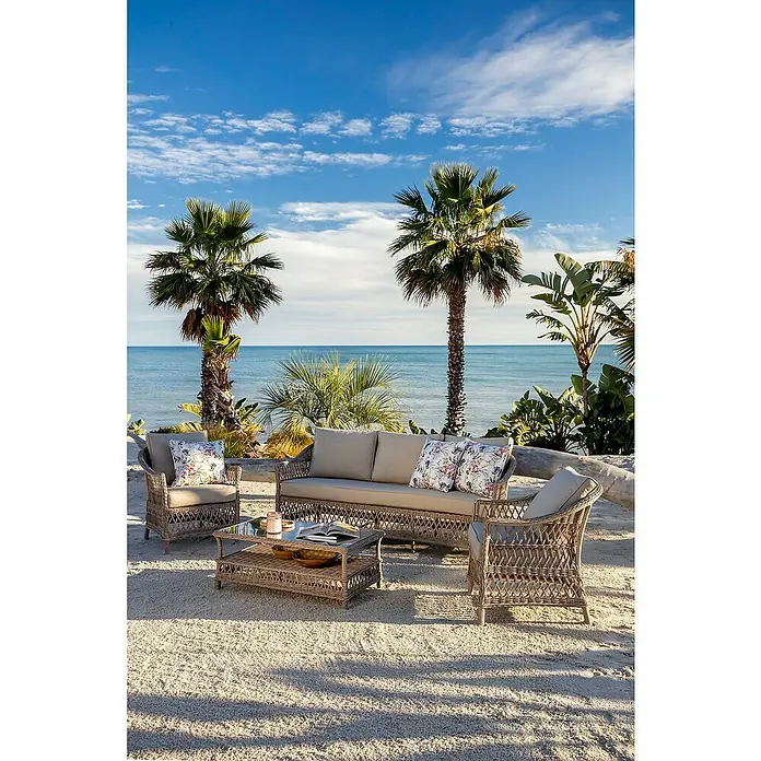 Sunfun Conjunto de muebles Soraya - 4 pzs., Ratán sintético/Aluminio/Poliéster, Beige/Gris - Conjunto de salón de mimbre para exterior con cojines claros: sofá, dos sillones y mesa de centro, en una playa.