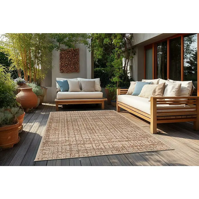 Outdoor-Teppich Fiesta - 150 x 80 cm - Rechteckiger beiger und brauner Outdoor-Teppich mit Muster auf einer Holzterrasse, zwischen zwei Outdoor-Sofas.