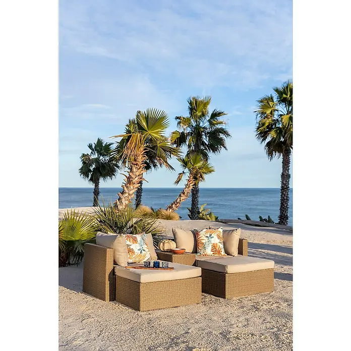 Conjunto de muebles Serena - 5 pzs., Ratán sintético/Aluminio, Marrón/Beige - Dos tumbonas de exterior de ratán beige con cojines claros y almohadas tropicales en una playa de arena.