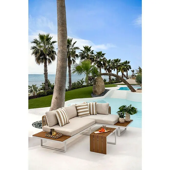 Conjunto de muebles Lynne - 3 pzs., Aluminio/Polywood/Poliéster, Blanco/Beige - Sofá seccional exterior beige con estructura blanca y mesas de madera en un patio junto a la piscina, con vistas al mar.